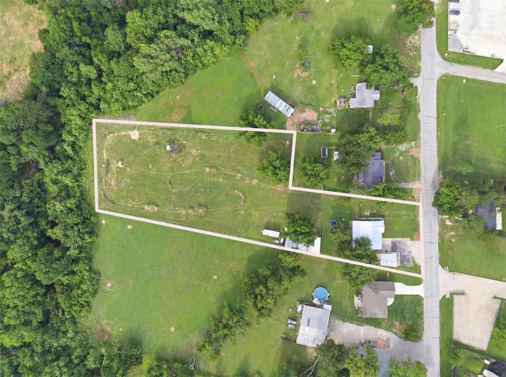 308 West 1st Street Springtown, TX 76082 - Photo 37 of 39 Expansive property featuring a cleared lot, surrounding mature trees, and direct road frontage