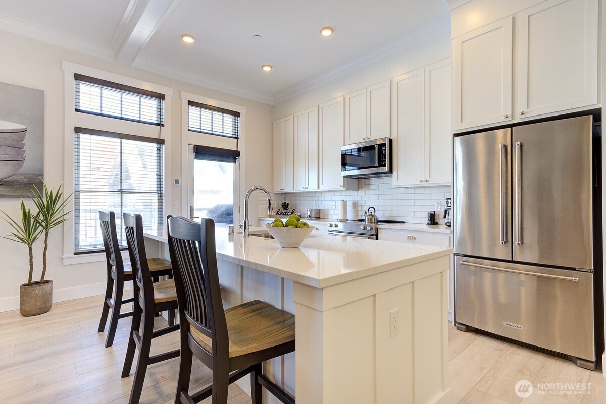204 Market Street, Unit B Pacific Beach, WA 98571 - Photo 17 of 25 a kitchen with stainless steel appliances granite countertop a dining table chairs refrigerator and sink