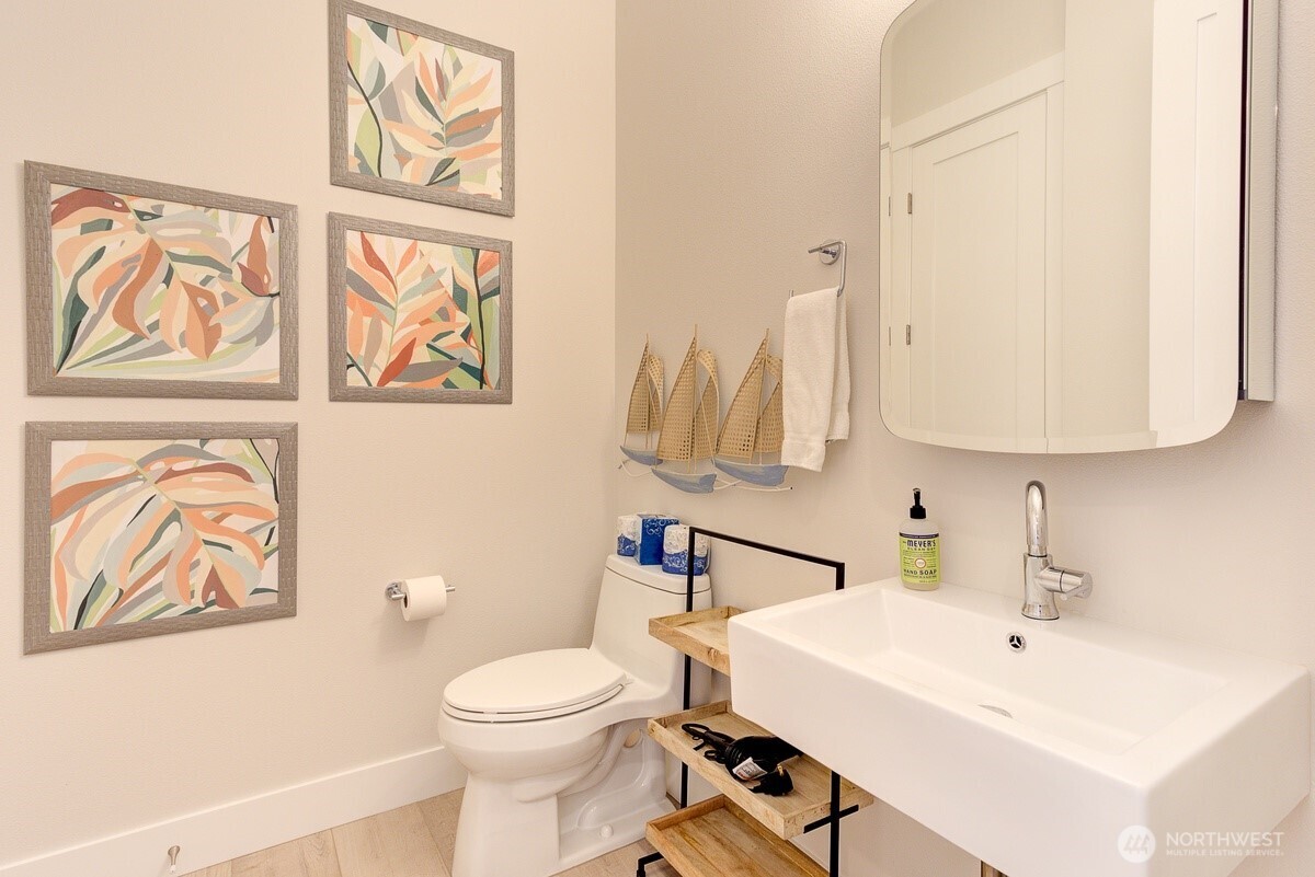 204 Market Street, Unit B Pacific Beach, WA 98571 - Photo 7 of 25 a bathroom with a sink a toilet and a mirror