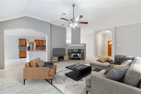 a living room with furniture a fireplace and a chandelier