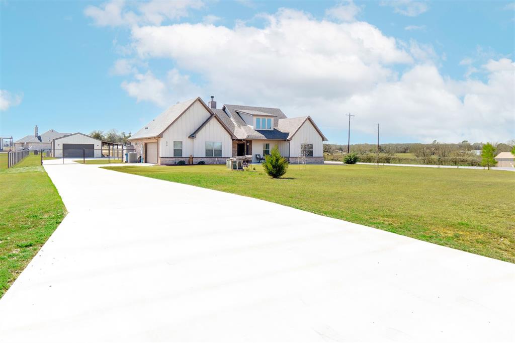 849 County Road 4764 Boyd, TX 76023 - Photo 2 of 40 a front view of a house with a big yard and potted plants