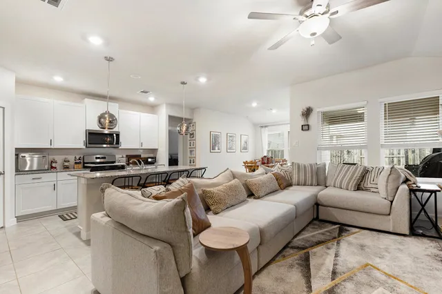 a living room with furniture and kitchen view