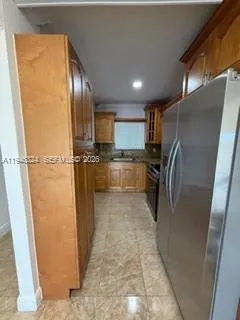 a kitchen with granite countertop a refrigerator and a sink