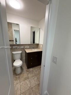 3011 West 76th Street, Unit A208 Hialeah, FL 33018 - Photo 5 of 14 a bathroom with a granite countertop toilet a sink and a mirror