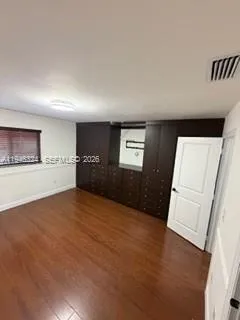 a view of an empty room and a kitchen
