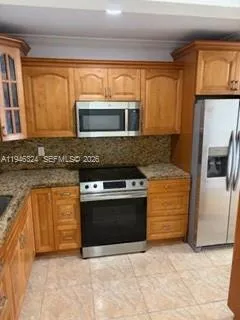 a kitchen with stainless steel appliances granite countertop a stove microwave and refrigerator