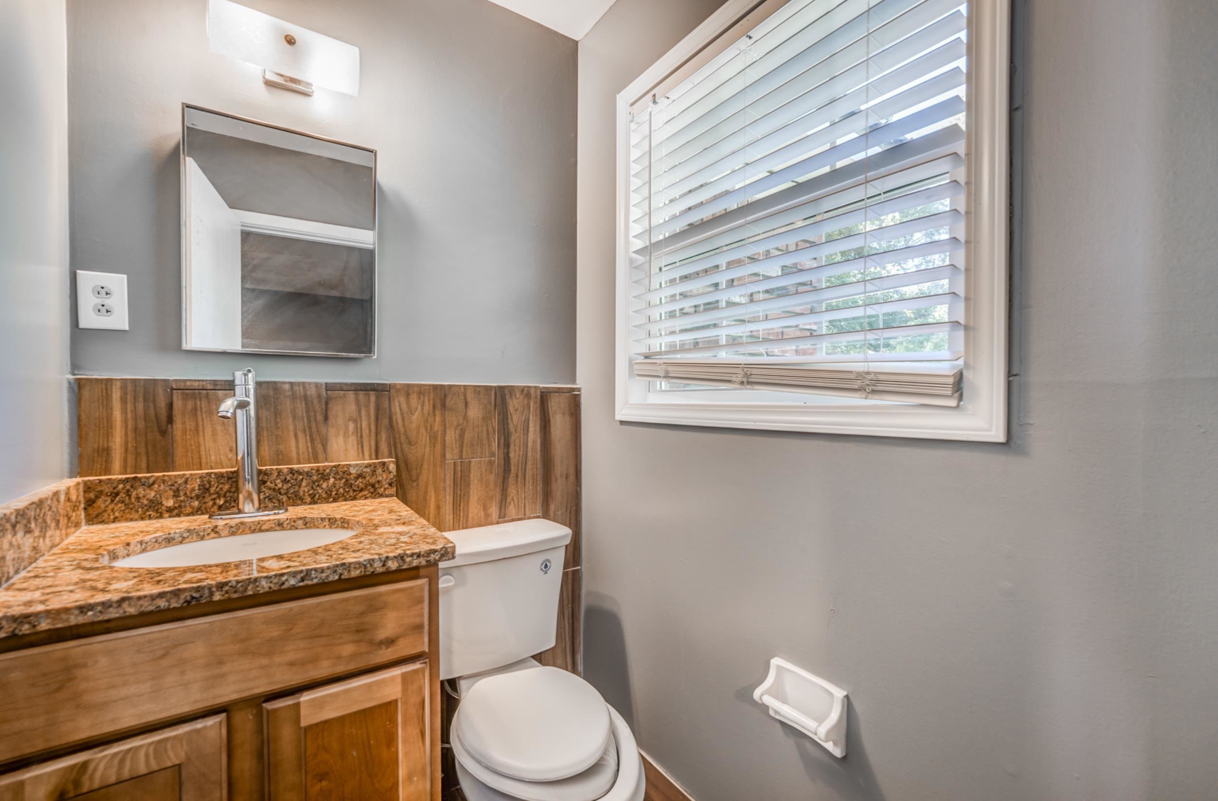 2865 Knightway Road Memphis, TN 38118 - Photo 17 of 19 a bathroom with a granite countertop toilet sink and mirror
