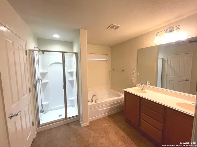 a bathroom with a tub sink shower and mirror
