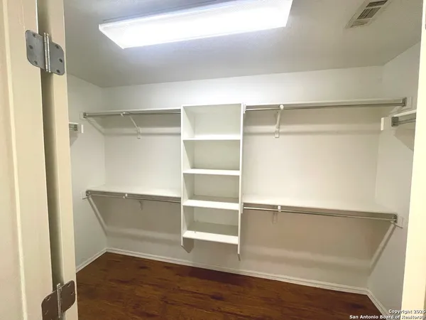 a view of walk in closet with empty racks