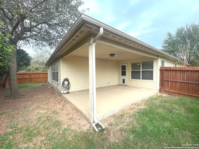 a backyard of a house with table and chairs
