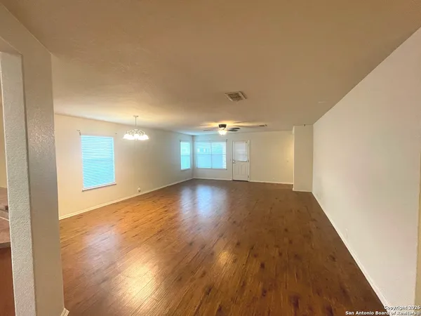 a view of empty room with wooden floor