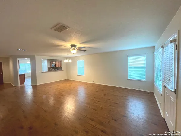 an empty room with wooden floor and windows