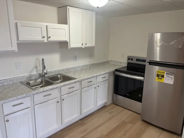 a kitchen with stainless steel appliances granite countertop white cabinets and a stove