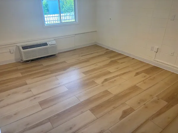 a room with a wooden floor and a window