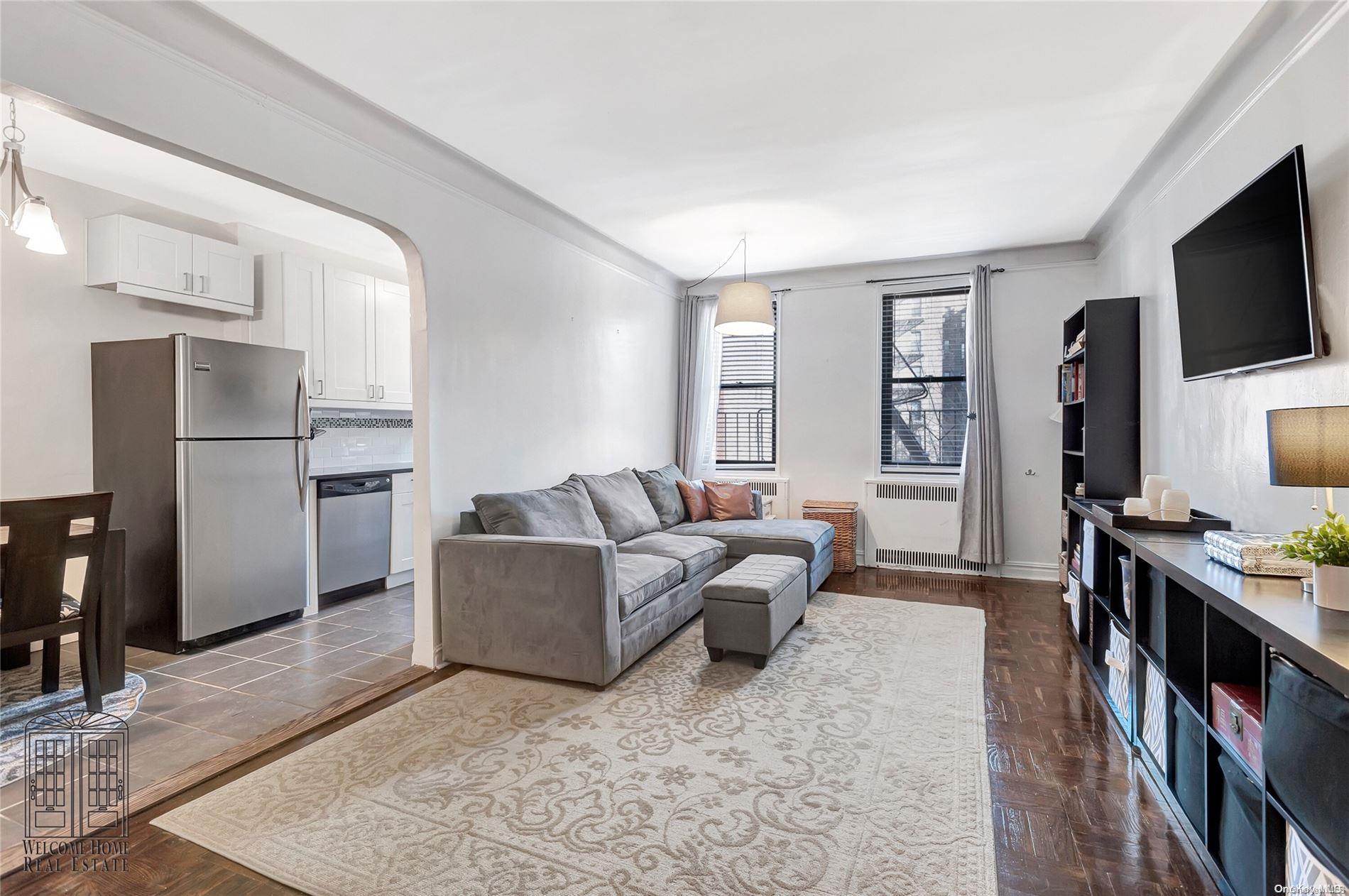 41-42 50th Street, Unit 4E Queens, NY 11377 - Photo 1 of 11 a living room with furniture and a flat screen tv