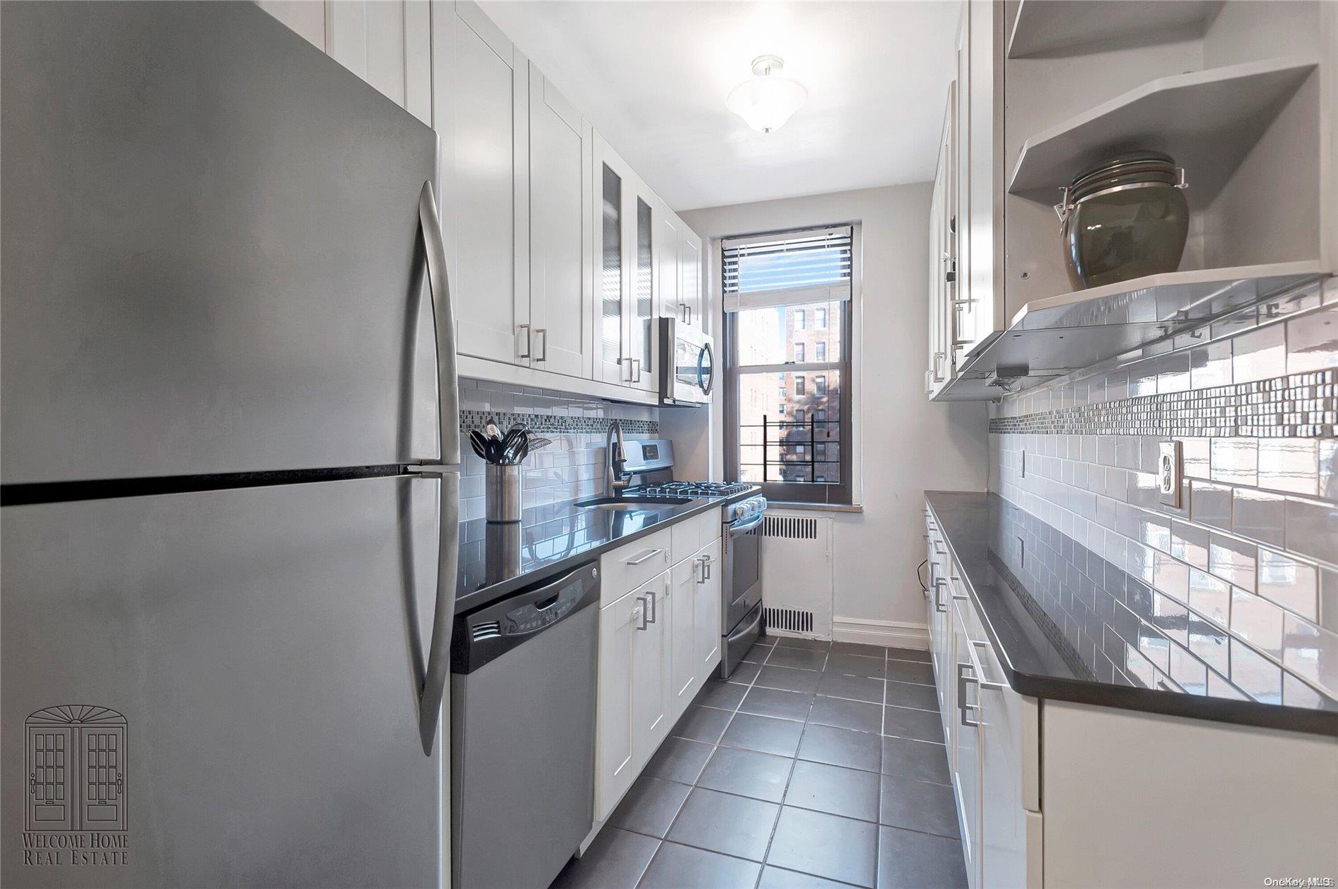 41-42 50th Street, Unit 4E Queens, NY 11377 - Photo 3 of 11 a kitchen with stainless steel appliances granite countertop a refrigerator and a sink