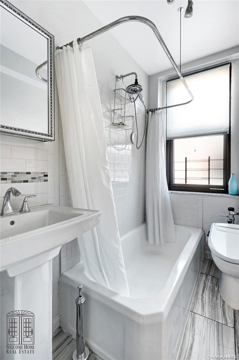 41-42 50th Street, Unit 4E Queens, NY 11377 - Photo 9 of 11 a bathroom with a sink and mirror