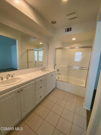 a spacious bathroom with a mirror sink and shower