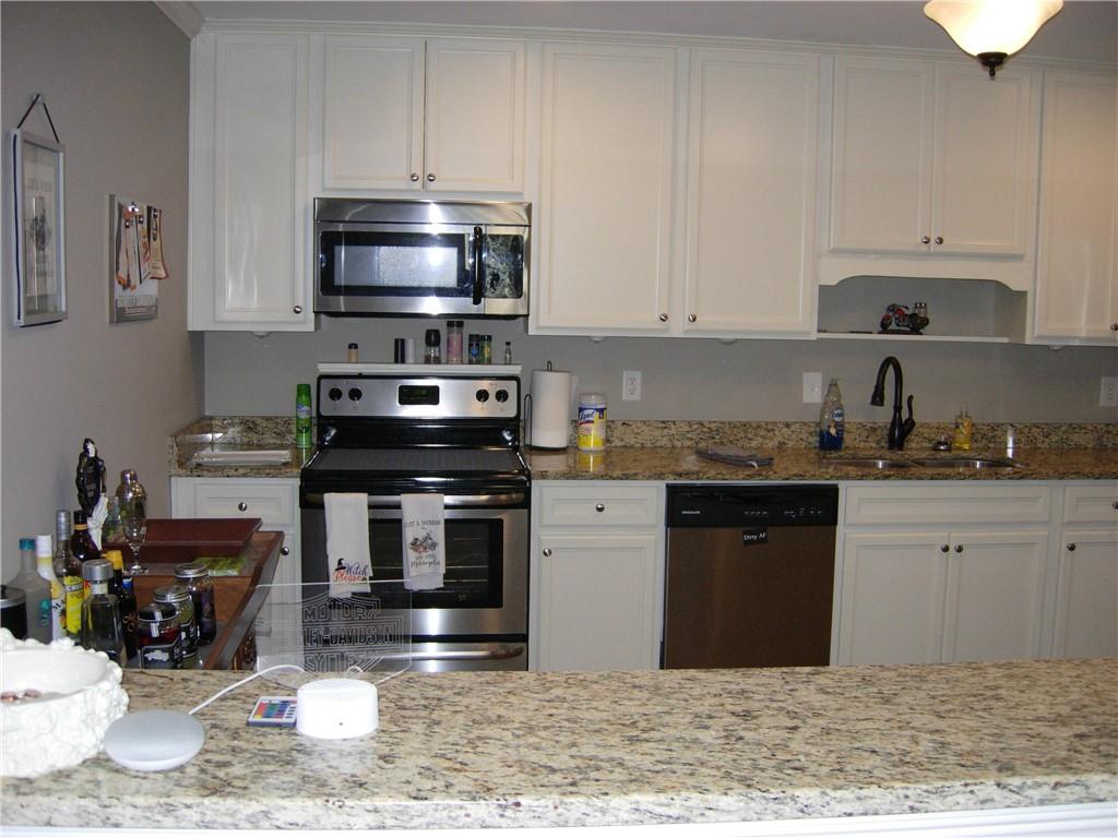 108 Millers Lane Calhoun, GA 30701 - Photo 5 of 21 a kitchen with stainless steel appliances granite countertop a stove a sink and a microwave