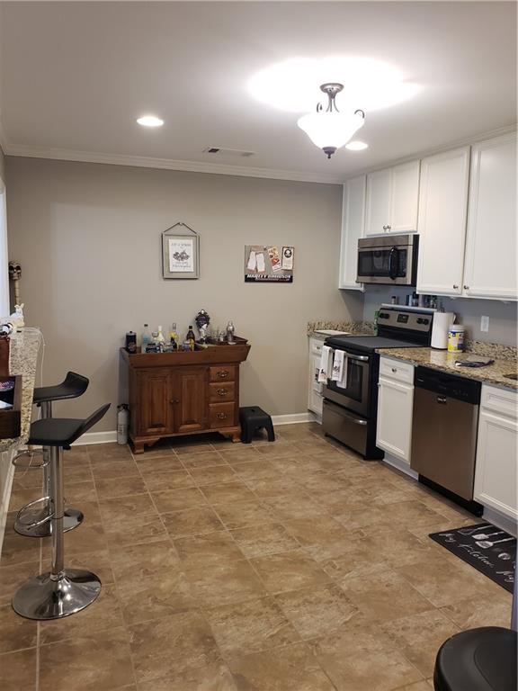 108 Millers Lane Calhoun, GA 30701 - Photo 6 of 21 a kitchen with stainless steel appliances granite countertop a stove and a refrigerator