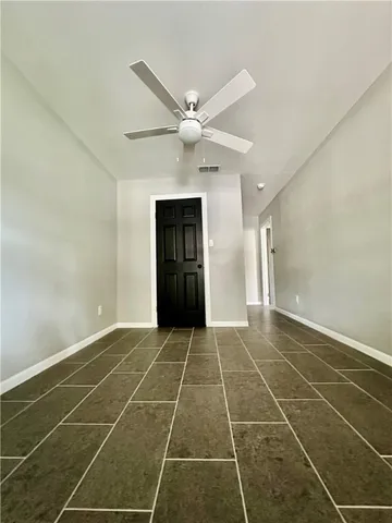 a view of an empty room with a ceiling fan and a window