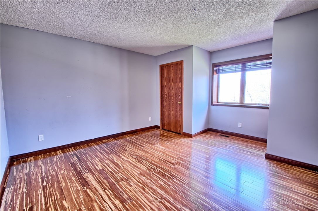 8711 Nicole Lane Springboro, OH 45066 - Photo 57 of 87 This spacious bedroom offers gleaming wood floors and a large window, providing a bright and inviting atmosphere.