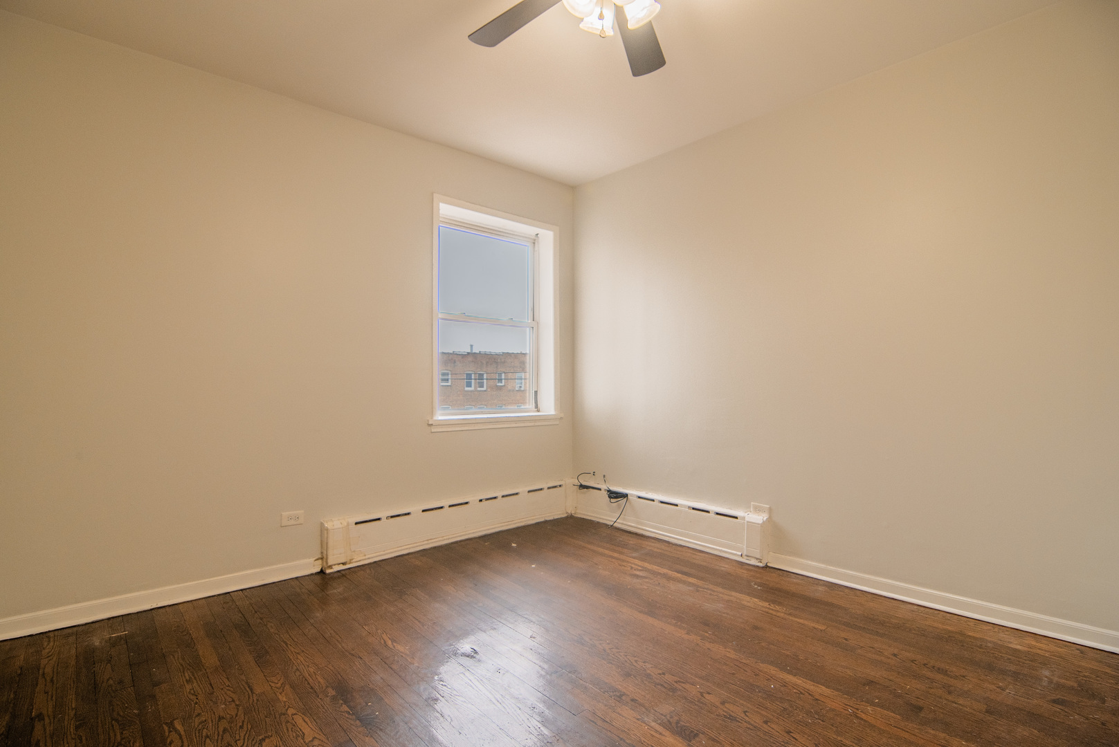 310 South Springfield Avenue, Unit 2S Chicago, IL 60624 - Photo 11 of 15 an empty room with wooden floor fan and windows