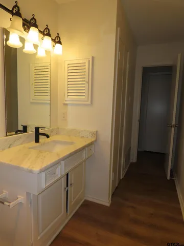 a bathroom with a granite countertop sink and a mirror