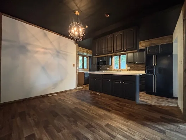 a kitchen with kitchen island granite countertop wooden cabinets and stainless steel appliances