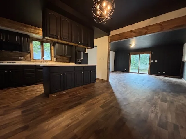 a kitchen with wooden cabinets and chandelier