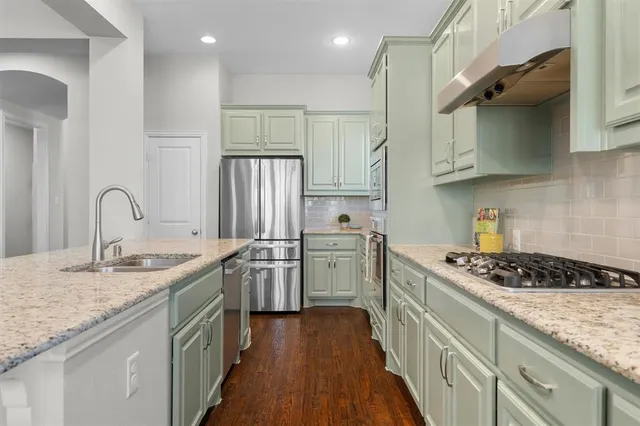 a kitchen with stainless steel appliances granite countertop a sink stove and cabinets