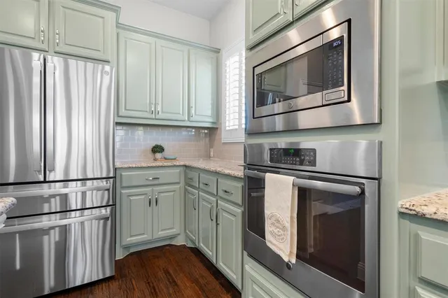 a kitchen with stainless steel appliances granite countertop a refrigerator microwave and sink