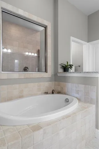 a bathroom with bathtub and mirror