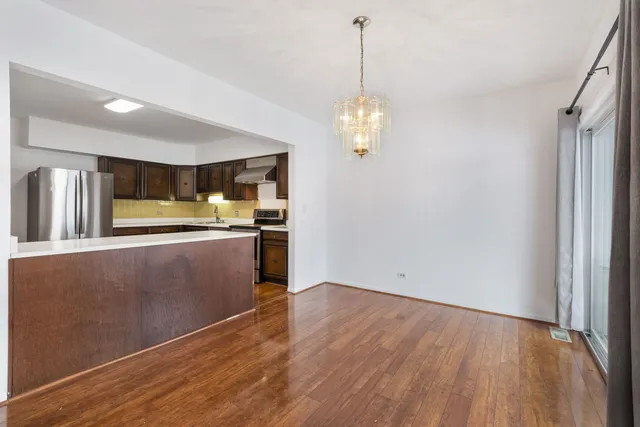 a view of a kitchen with wooden floor and stainless steel appliances
