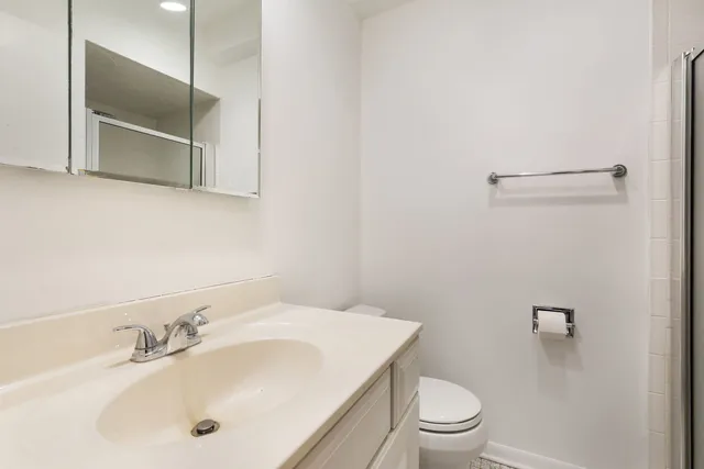 a bathroom with a sink a toilet and a mirror