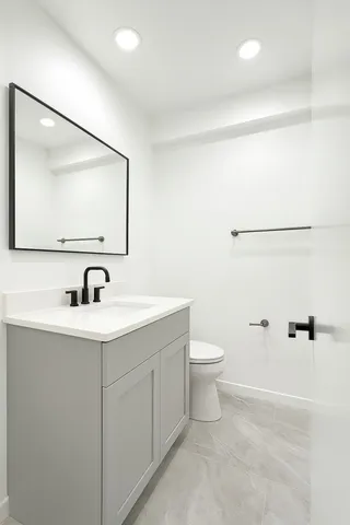 a bathroom with a toilet a sink and mirror