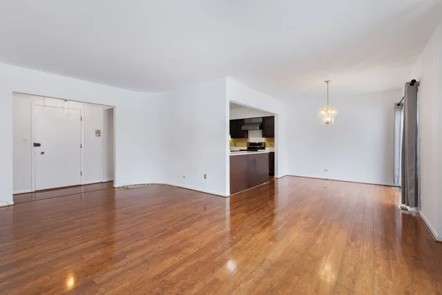 an empty room with wooden floor and bathroom