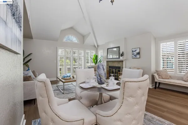a dining room with furniture a fireplace and wooden floor