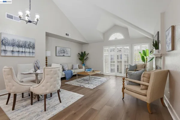a living room with furniture a chandelier and a window