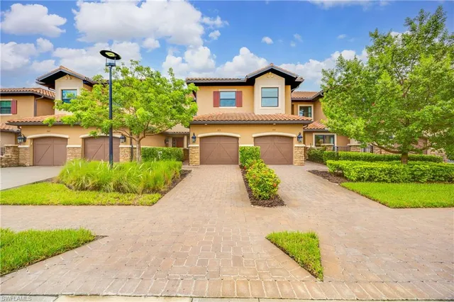 a front view of a house with a garden and plants