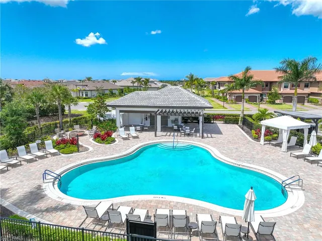a view of a swimming pool with lawn chairs under an umbrella