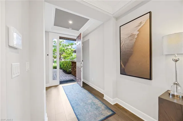 a view of a hallway with wooden floor and a bathroom