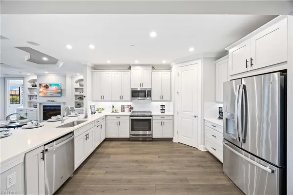 a kitchen with white cabinets and white appliances