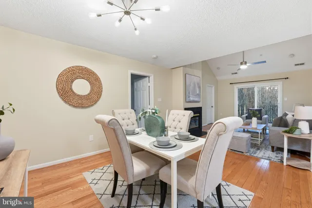 a dining room with furniture a chandelier and wooden floor