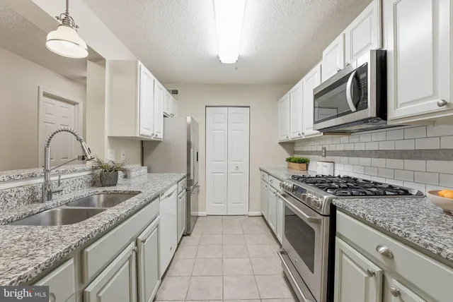 a kitchen with stainless steel appliances granite countertop a sink stove and cabinets