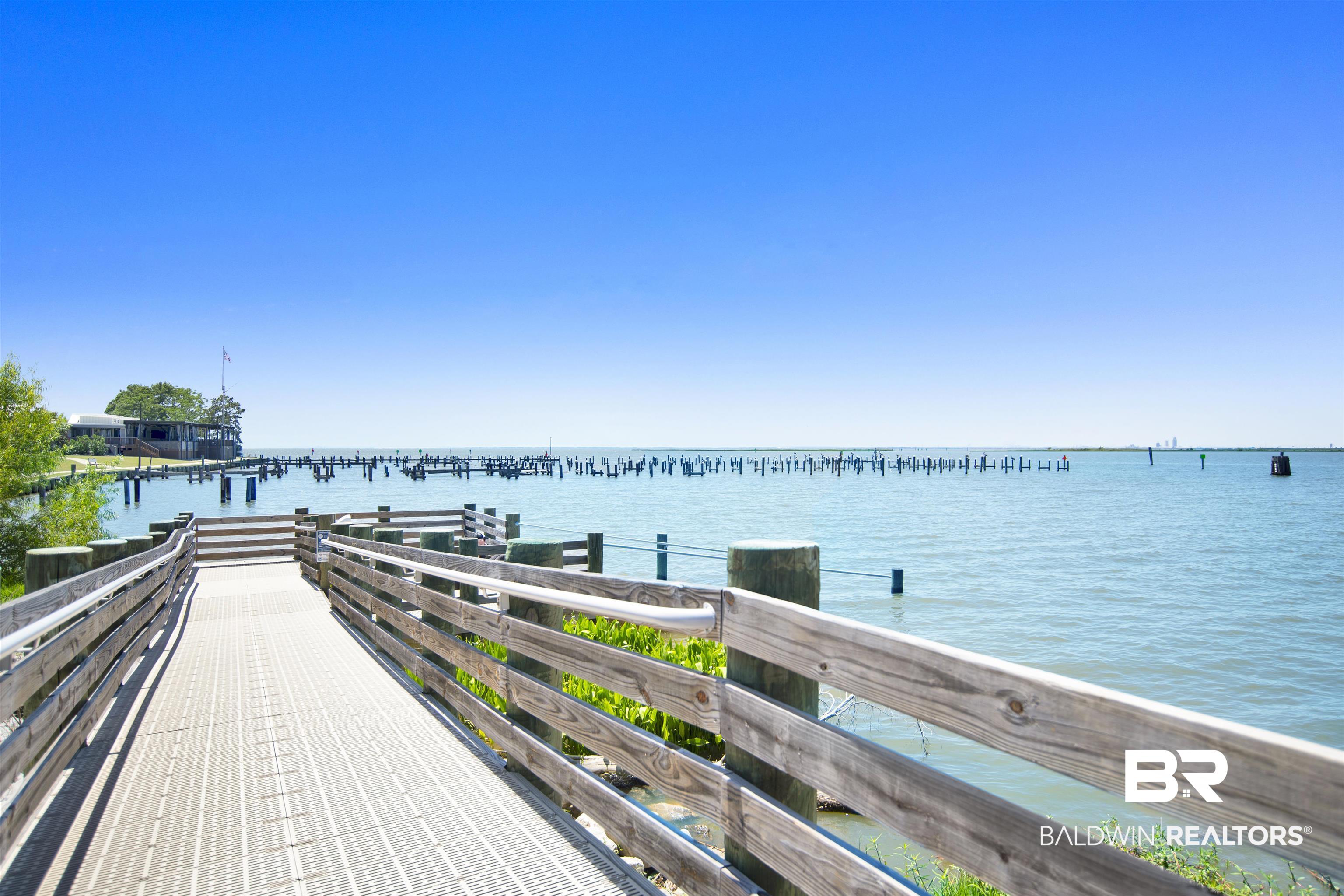 107 Virginia Circle Daphne, AL 36526 - Photo 38 of 47 Waterfront property featuring a wooden boardwalk, clear blue skies, and distant structures over the water