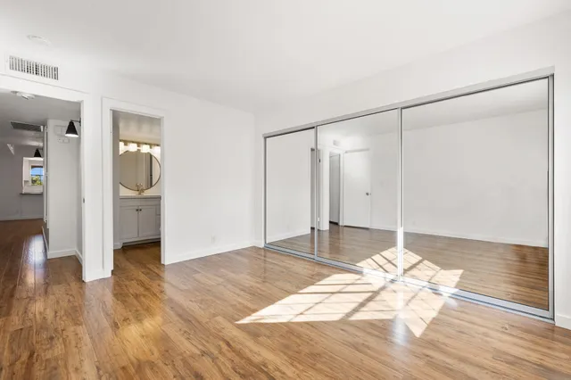 a view of empty room with wooden floor