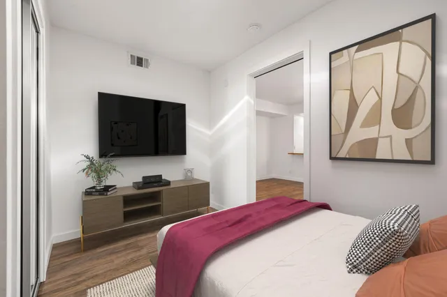 a bedroom with a bed and a flat screen tv