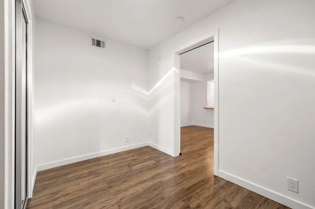 a view of an empty room with wooden floor