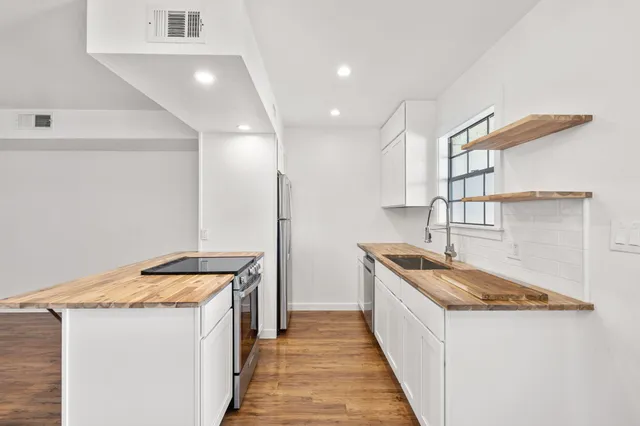 a kitchen with granite countertop a sink and a stove